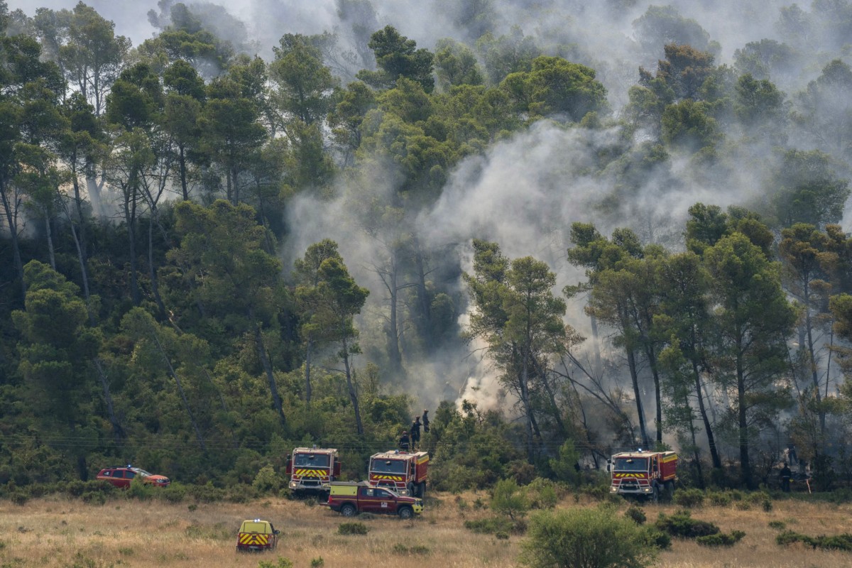 Bombeiros em uma área florestal em chamas durante incêndio florestal em Saint-Laurent-de-la-Cabrerisse, sul da França