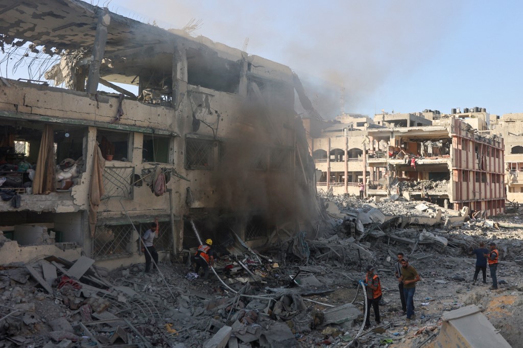 Palestinian rescuers extinguish a fire in a destroyed building following Israeli bombardment which hit a school complex, including the Hamama and al-Huda schools, in the Sheikh Radwan neighbourhood in the north of Gaza City on August 3, 2024, amid the ongoing conflict between Israel and the militant Hamas group. (Photo by Omar AL-QATTAA / AFP)