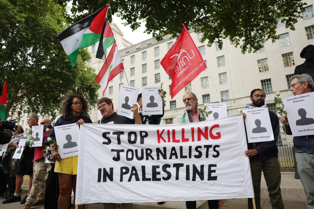 Manifestantes erguem faixa durante protesto pelas mortes de jornalistas na Faixa de Gaza | Foto: Toby Shepheard/AFP