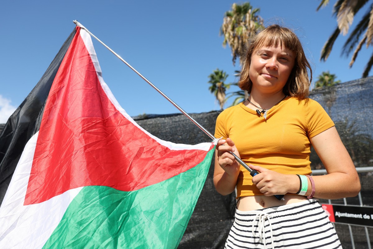 A ativista climática sueca Greta Thunberg posa com uma bandeira palestina