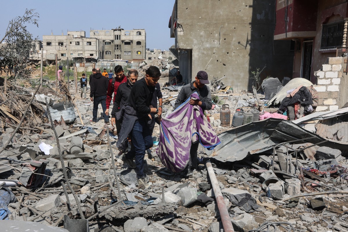 Palestinos carregam corpo de uma das vítimas dos bombardeios desta terça-feira, em Gaza