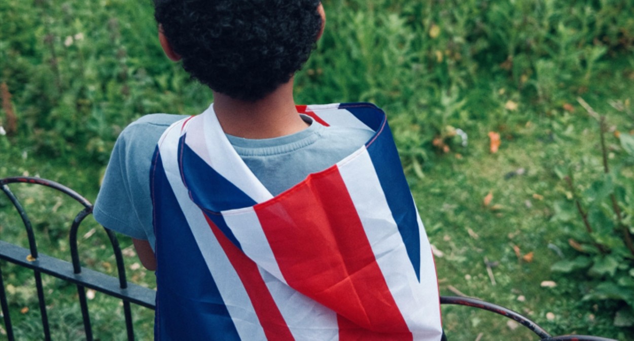 Imagem ilustrativa de uma criança com uma bandeira da Inglaterra