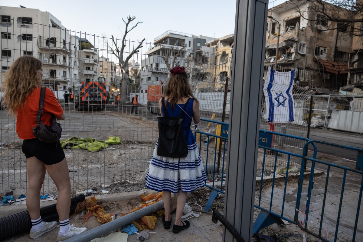 Pessoas visitam o local de um ataque com mísseis iranianos no centro de Tel Aviv