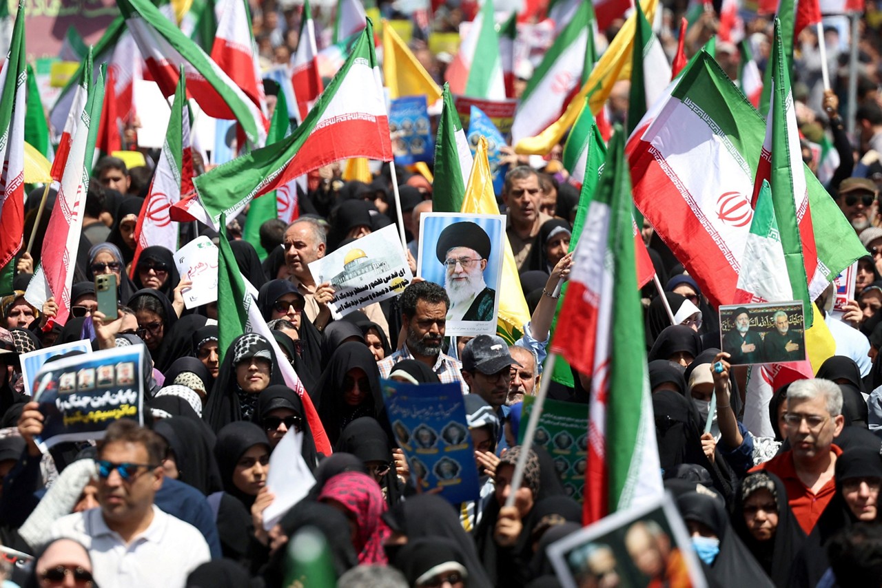 Iranianos agitam sua bandeira nacional e cartazes durante um protesto anti-Israel em Teerã, em 20 de junho