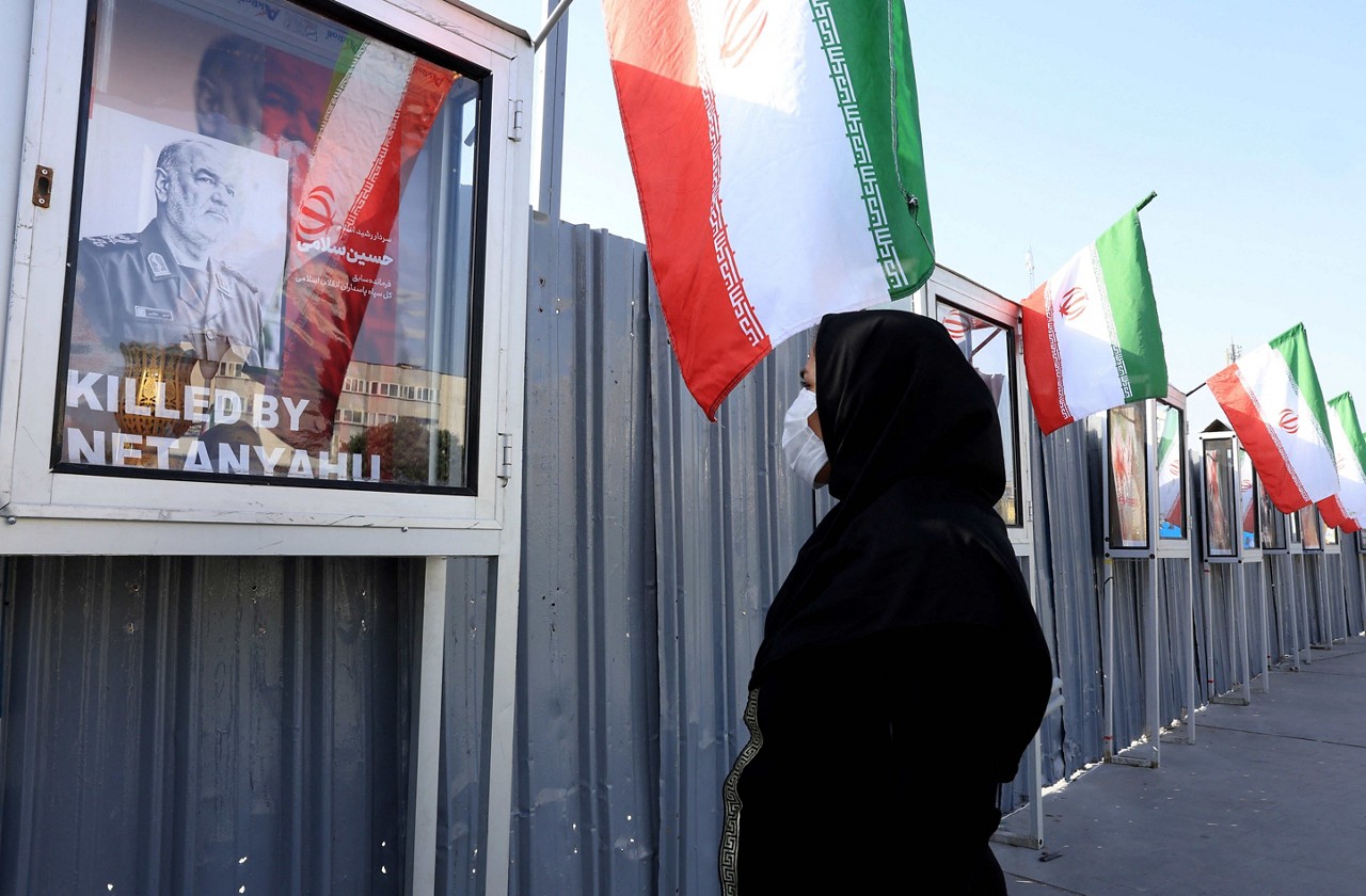 Uma mulher iraniana observa a imagem do comandante do Corpo da Guarda Revolucionária Islâmica Iraniana (IRGC), Hossein Salami, morto após ataques israelenses contra alvos no Irã