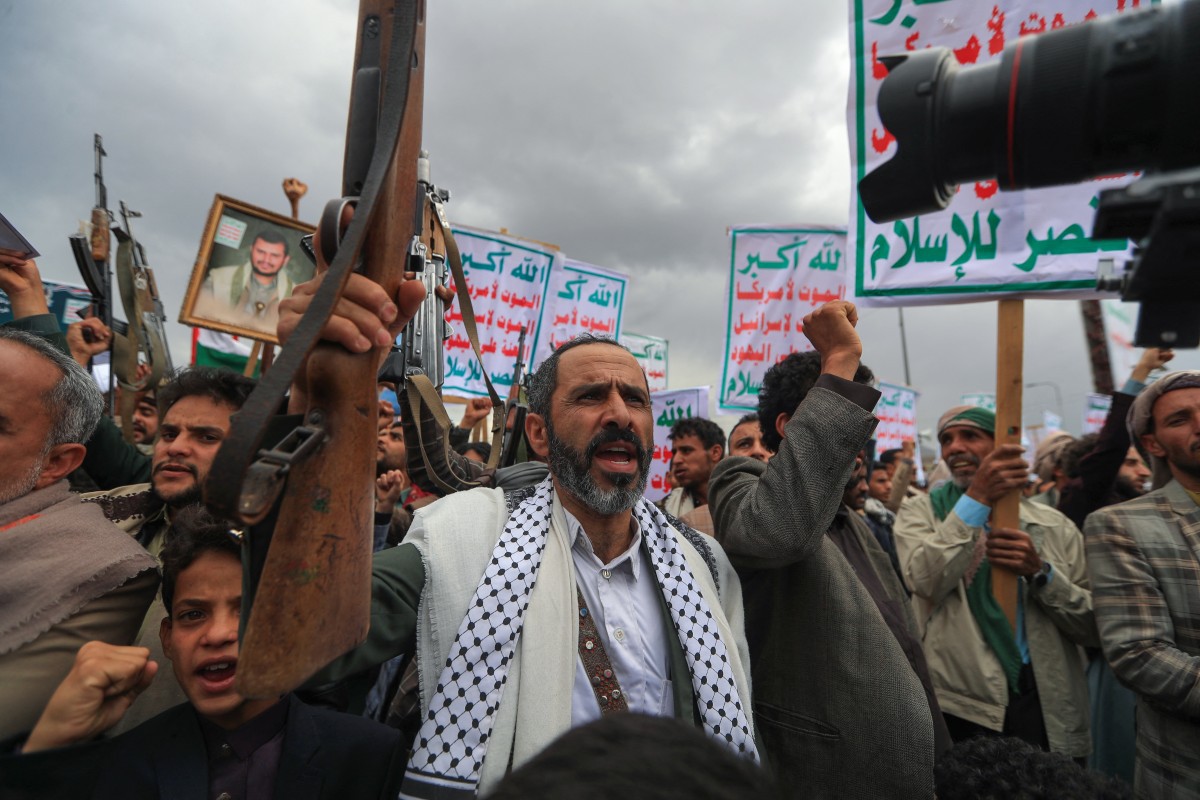Iemenitas erguem cartazes e rifles tradicionais durante um protesto em solidariedade aos palestinos. Foto: Mohammed HUWAIS / AFP