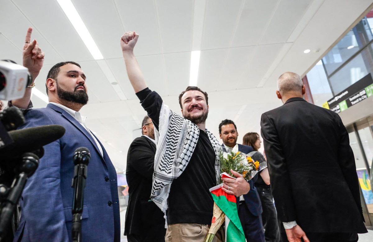 Mahmoud Khalil acena ao chegar ao aerporto de Newark, em Nova Jersey (Photo by kena betancur / AFP)