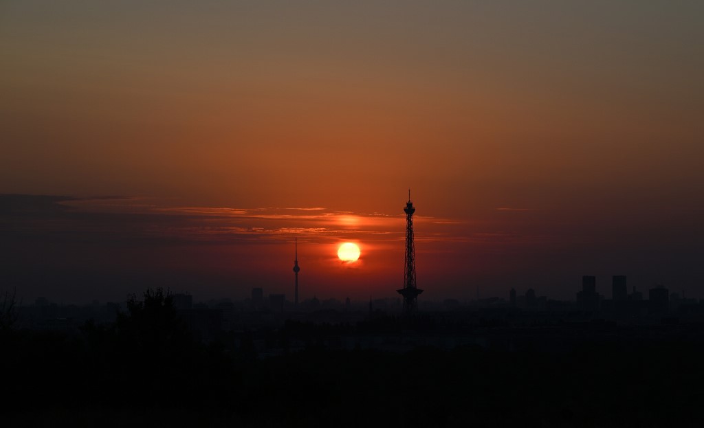 Berlin's landmarks the Funkturm radio tower (C-R) and the Fernsehturm tv tower (background C-L) silhouette against the sky sky as sun rises over the German capital on September 6, 2024. (Photo by Ralf Hirschberger / AFP)