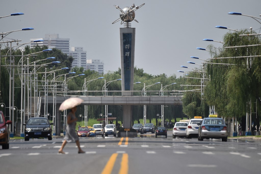 Mulher caminha por avenida de Pyongyang, capital da Coreia do Norte