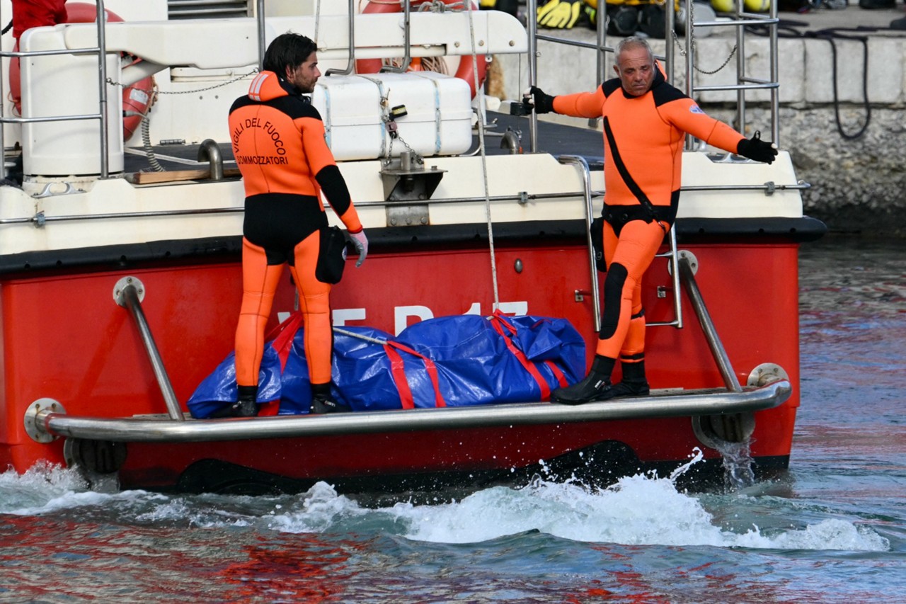 Imagem de autoridades italianas resgatam o corpo de uma das sete vítimas do naufrágio