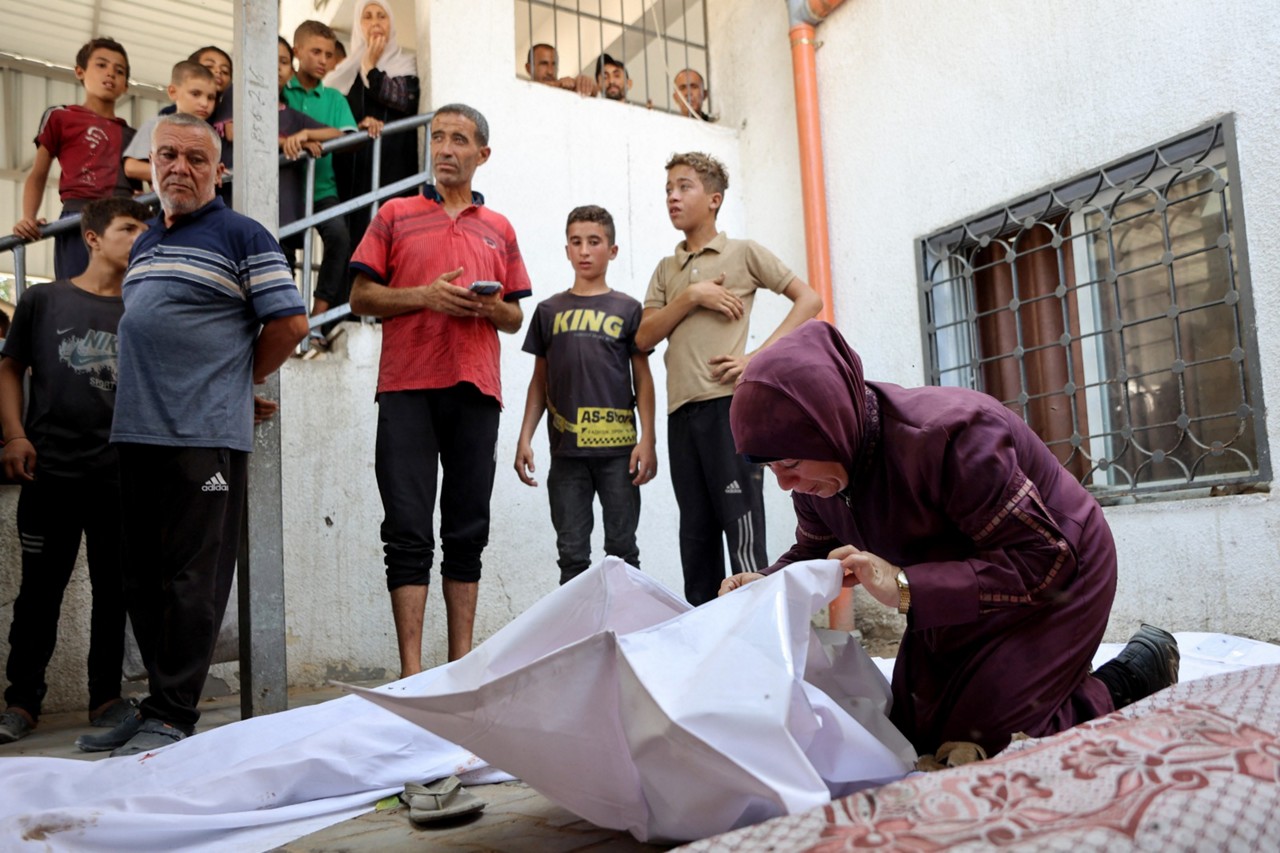 Mulher palestina lamenta o corpo mortalmente envolto de uma criança morta em um ataque israelense 