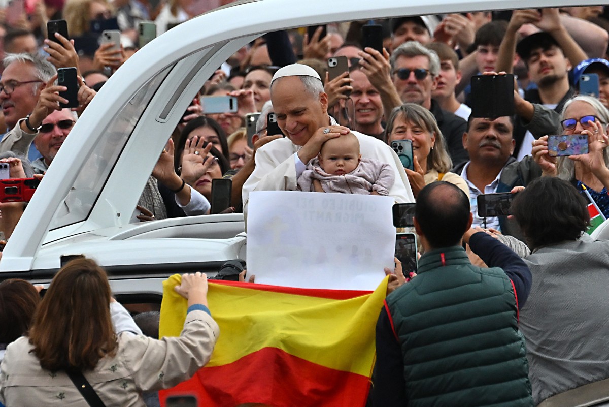 O Papa Leão XIV segura bebê no colo no papamóvel ao sair da Praça de São Pedro, no Vaticano, após a Missa do Jubileu para o Mundo e os Migrantes