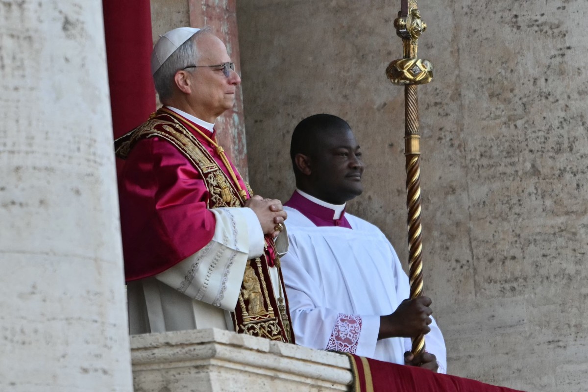 O recém-eleito Papa Robert Francis Prevost, Papa Leão XIV, (L) chega à varanda principal da loggia central da Basílica de São Pedro pela primeira vez, depois que os cardeais encerraram o conclave, no Vaticano, em 8 de maio de 2025. Robert Francis Prevost foi eleito na quinta-feira o primeiro papa dos Estados Unidos, anunciou o Vaticano. Um moderado que era próximo ao Papa Francisco e ou anos como missionário no Peru, ele se torna o 267º pontífice da Igreja Católica, assumindo o nome papal Leão XIV. (Foto de Andrej ISAKOVIC / AFP)