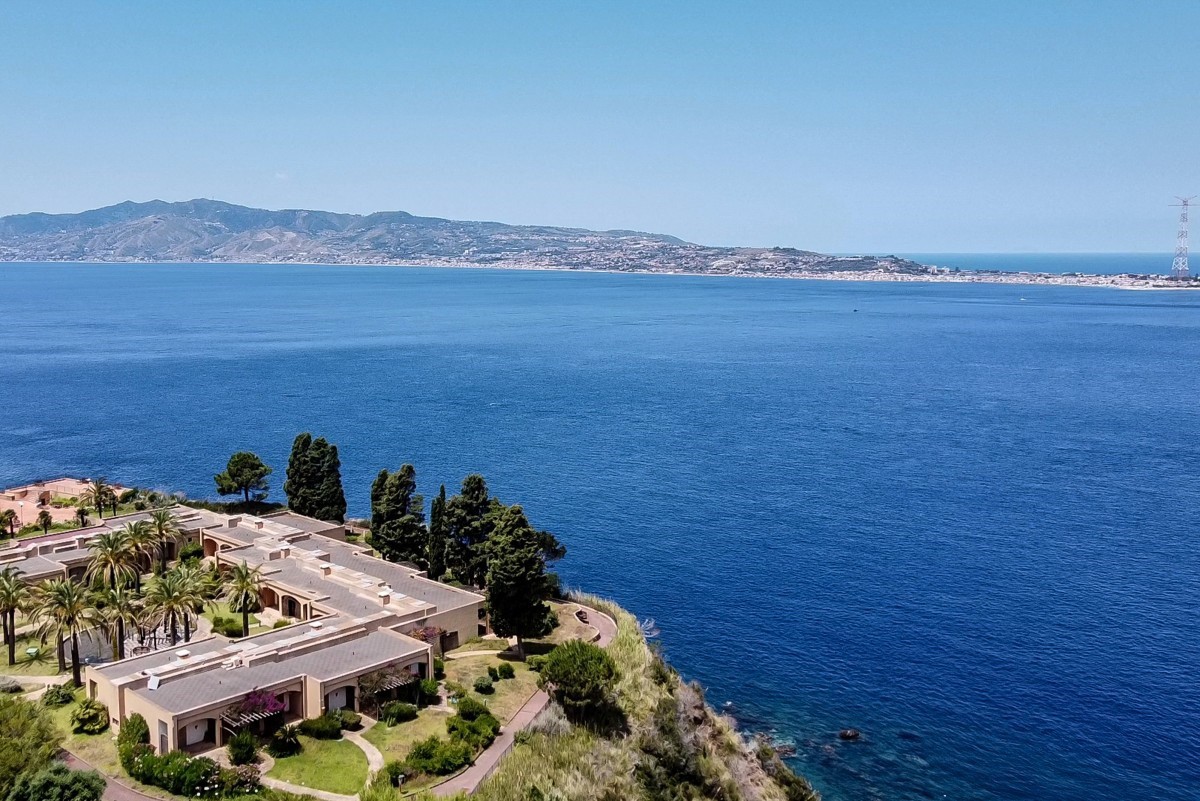 (FILES) A general aerial view shows the Sicilian coast towards Cape Torre Faro, over the Strait of Messina, taken from the outskirts of the town of Scilla, in Calabria region in southern Italy, on July 7, 2020. Italy's government on August 6, 2025 approved a 13.5-billion-euro ($15.6-billion) project to build the world's longest suspension bridge connecting the island of Sicily to the mainland. (Photo by Andreas SOLARO / AFP)
