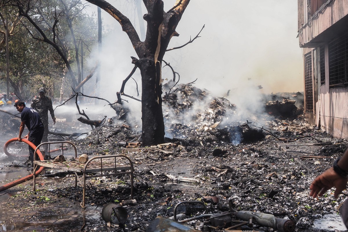 Bombeiros trabalham no local onde o voo 171 da Air India caiu em uma área residencial perto do aeroporto de Ahmedabad
