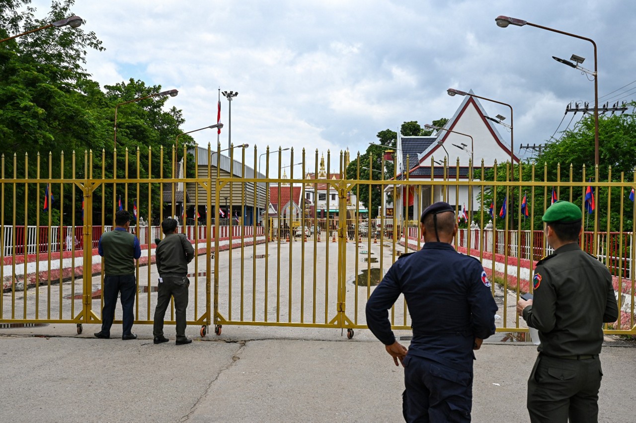 Policiais cambojanos ao lado do portão fechado no posto de controle da fronteira internacional de Poipet, entre o Camboja e a Tailândia, na cidade de Poipet, província de Banteay Meanchey, em 24 de junho de 2025. O exército da Tailândia fechou as passagens de fronteira com o Camboja em seis províncias no dia 23 de junho para todos os veículos e passageiros a pé, exceto estudantes e pessoas em busca de tratamento médico, em meio a uma disputa territorial entre os países vizinhos.