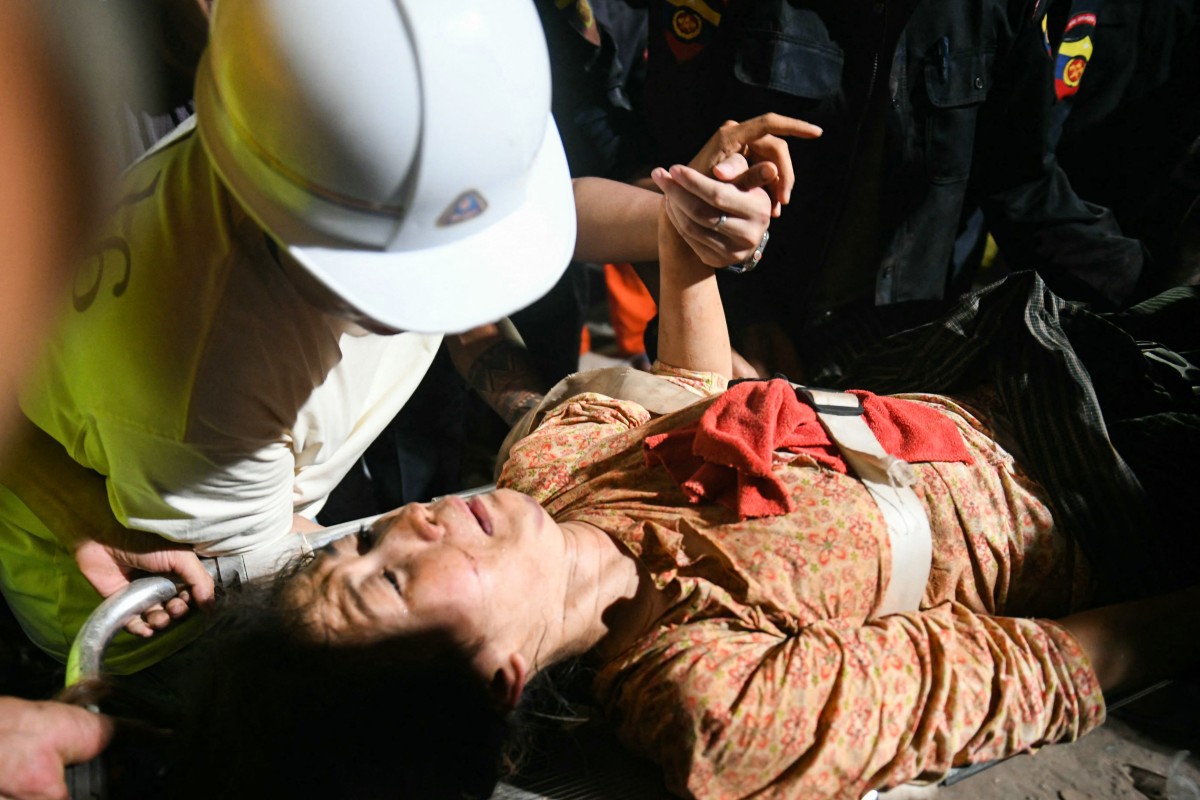 Mulher é resgatada de escombros de edifício em Mandalay, Mianmar (Photo by Sai Aung MAIN  AFP)