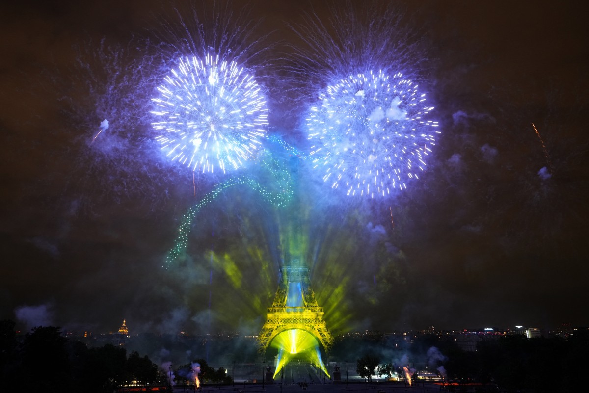 Fogos de artifício são acesos ao redor da Torre Eiffel durante um show coreografado de fogos de artifício e drones para celebrar o Dia da Bastilha, em Paris