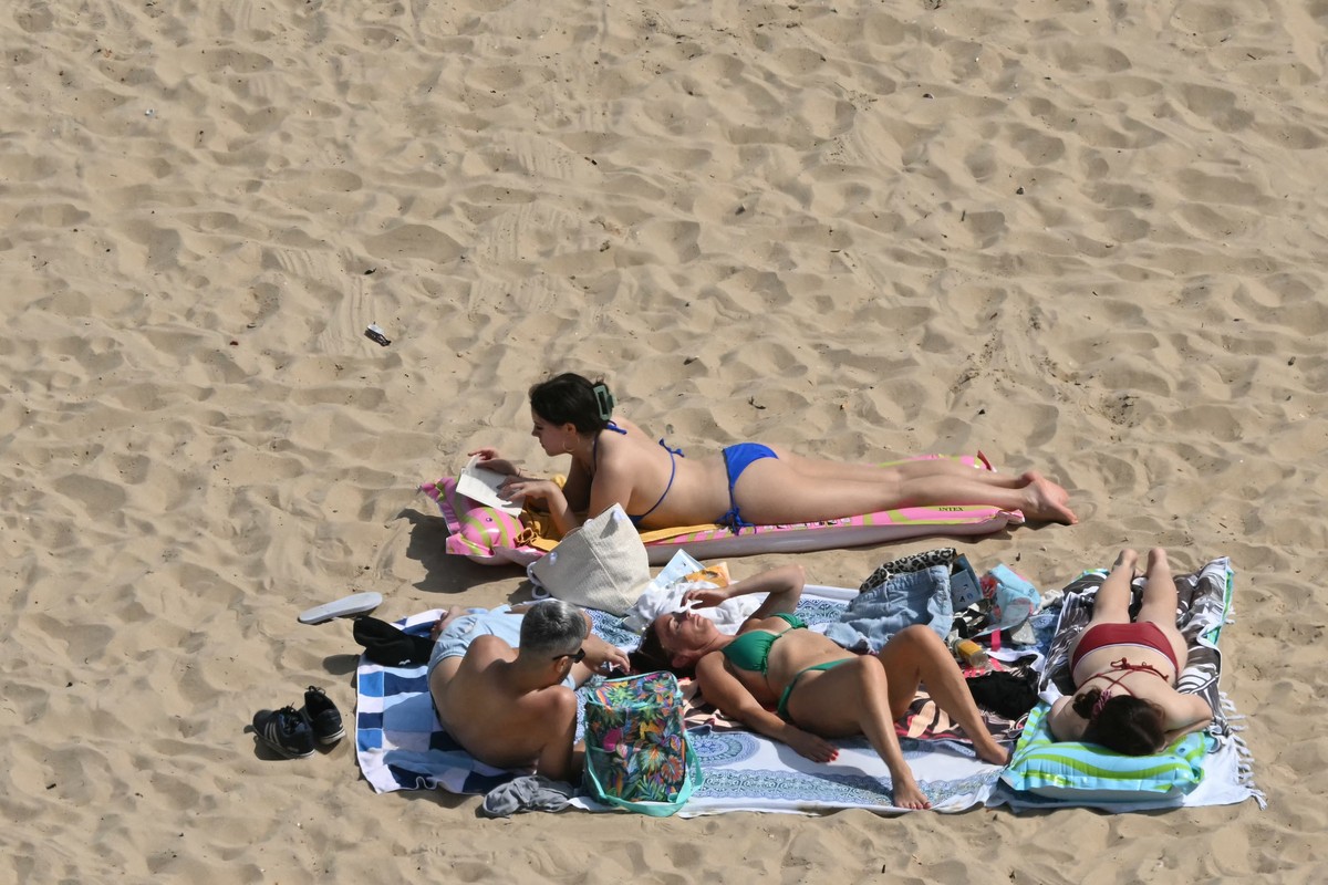 Banhistas relaxam ao sol na praia de Bournemouth, na costa sul da Inglaterra neste domingo, 29