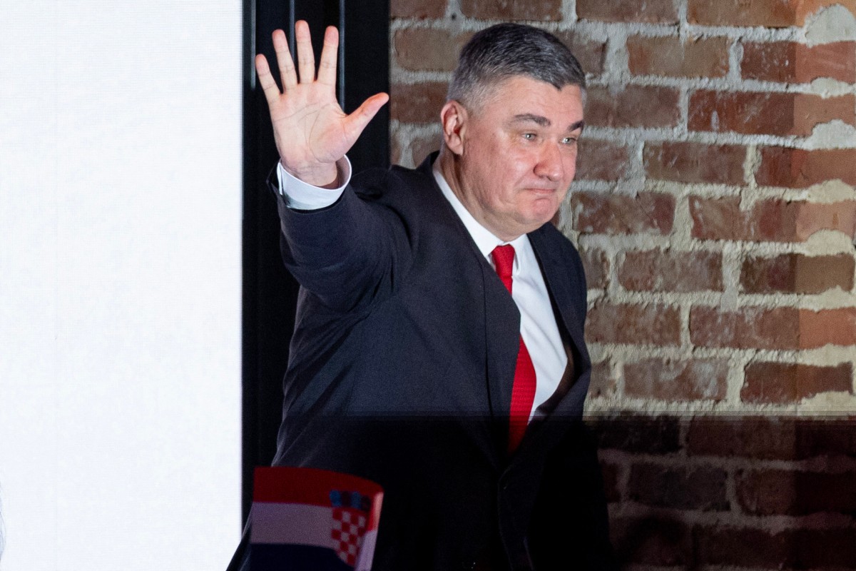 O presidente e candidato presidencial Zoran Milanovic acena enquanto sobe ao palco em Zagreb