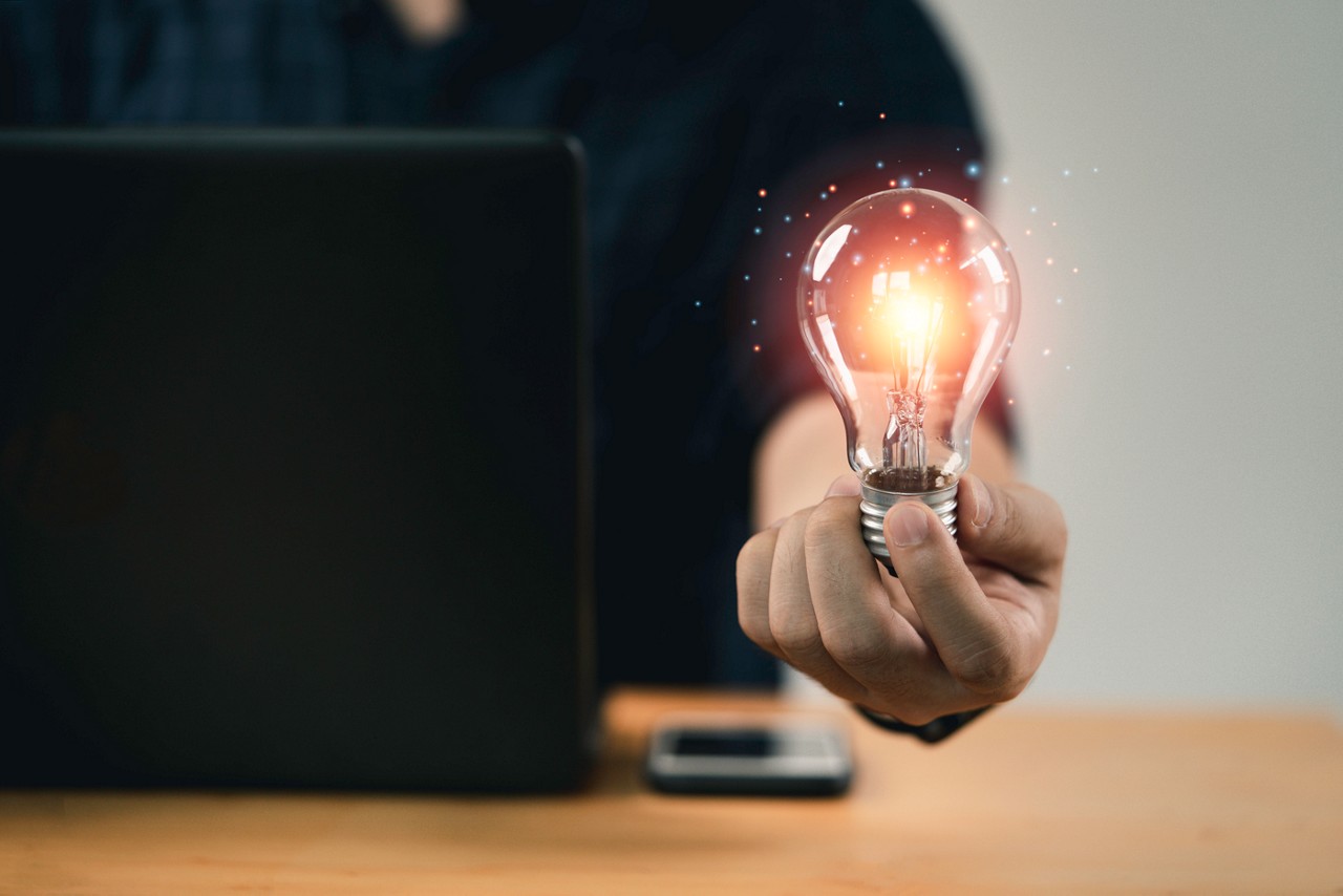 Businessman hand holding lightbulb with glowing light to creative smart thinking for inspiration and innovation with network concept.