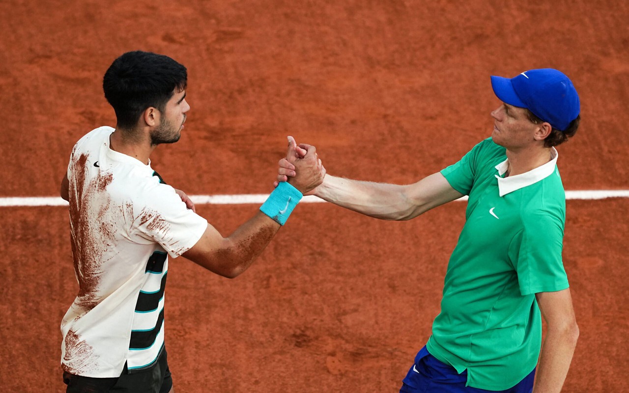O espanhol Carlos Alcaraz e o italiano Jannik Sinner se cumprimentam após a épica final de Roland Garros (Foto: Dimitar DILKOFF / AFP)