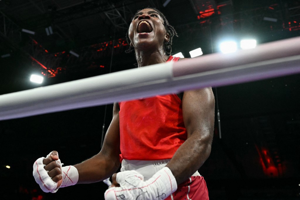 Refugee Olympic Team's Cindy Winner Djankeu Ngamba reacts after beating France's Davina Michel in the women's 75kg quarter-final boxing match during the Paris 2024 Olympic Games at the North Paris Arena, in Villepinte on August 4, 2024. (Photo by MOHD RASFAN / AFP)