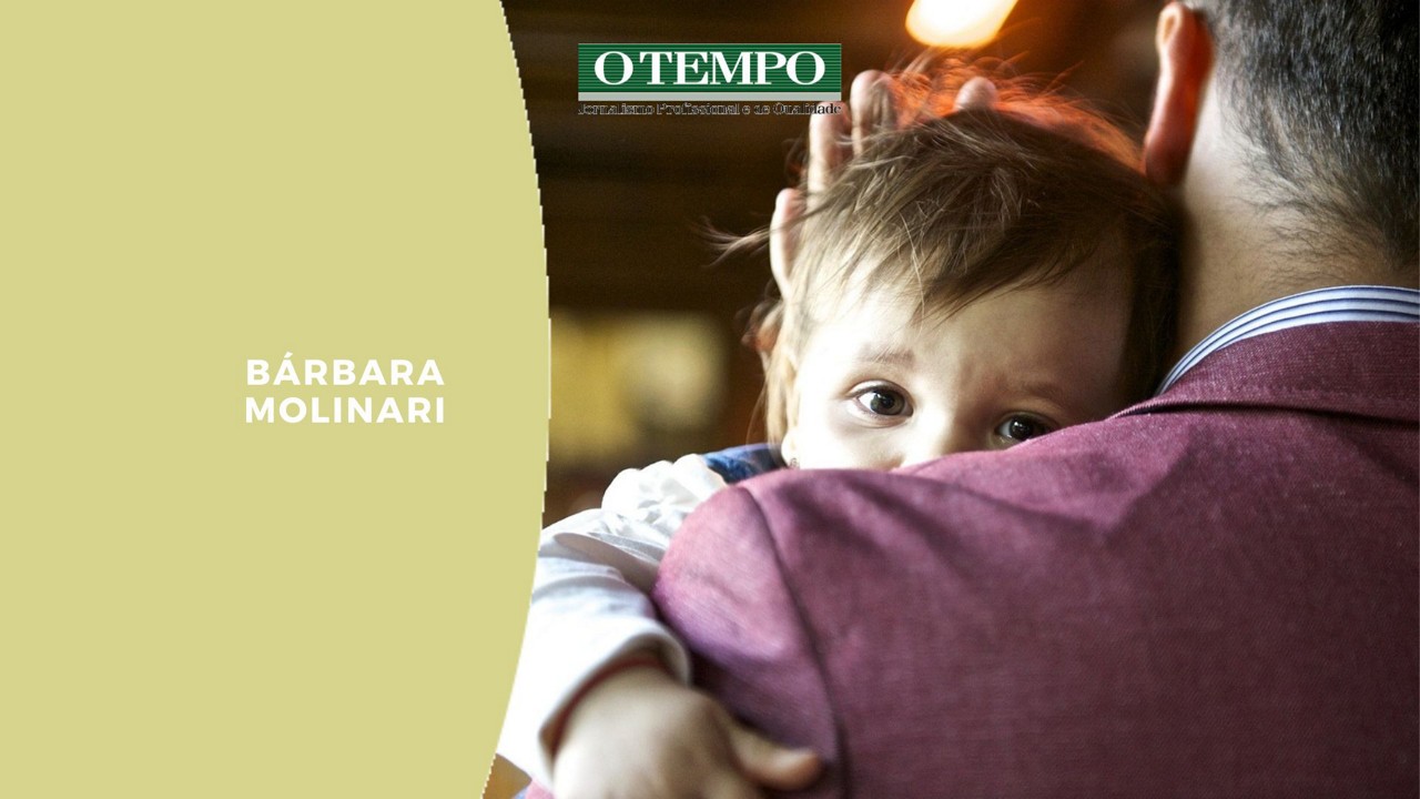 Pai acalenta criança no ombro