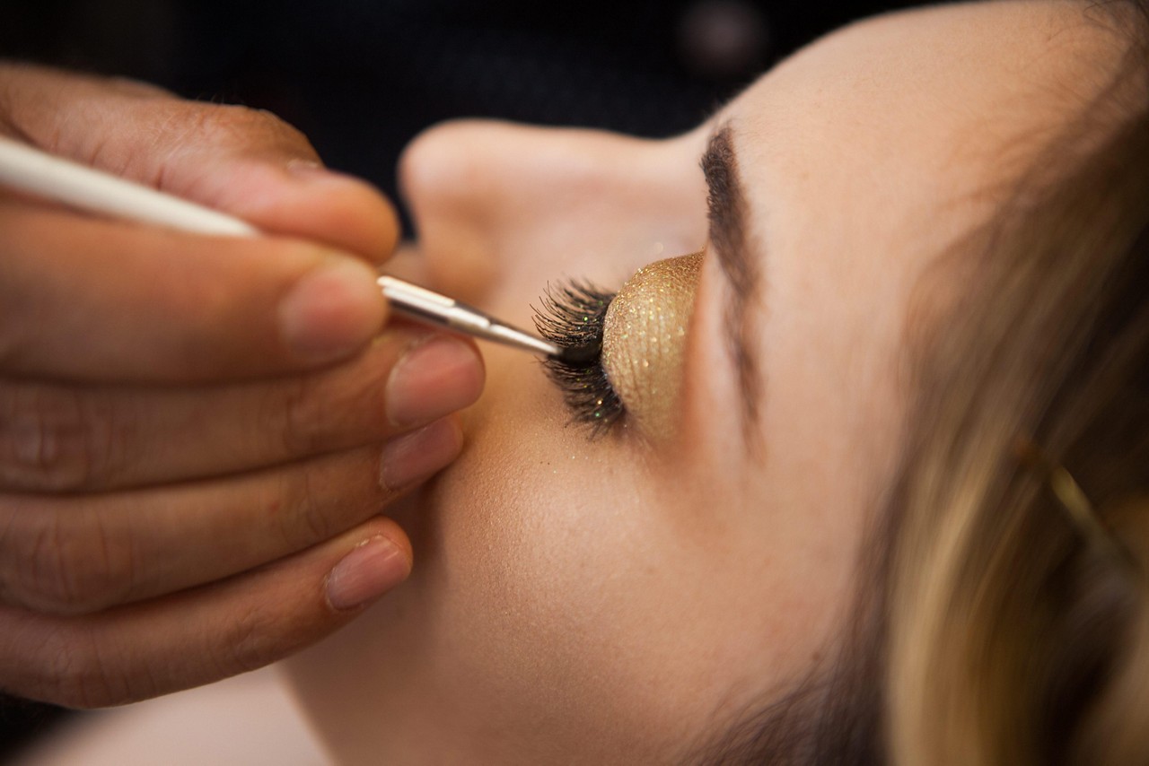 Olhos. Uma dica é aplicar uma sombra opaca no côncavo para dar mais profundidade. Prefira os tons de nude com aspecto de envelhecido. Ela serve de base para usar o glitter dourado na pálpebra móvel. Se você tiver habilidade, vale até um cílios postiços, arrematando com máscara de cílios.