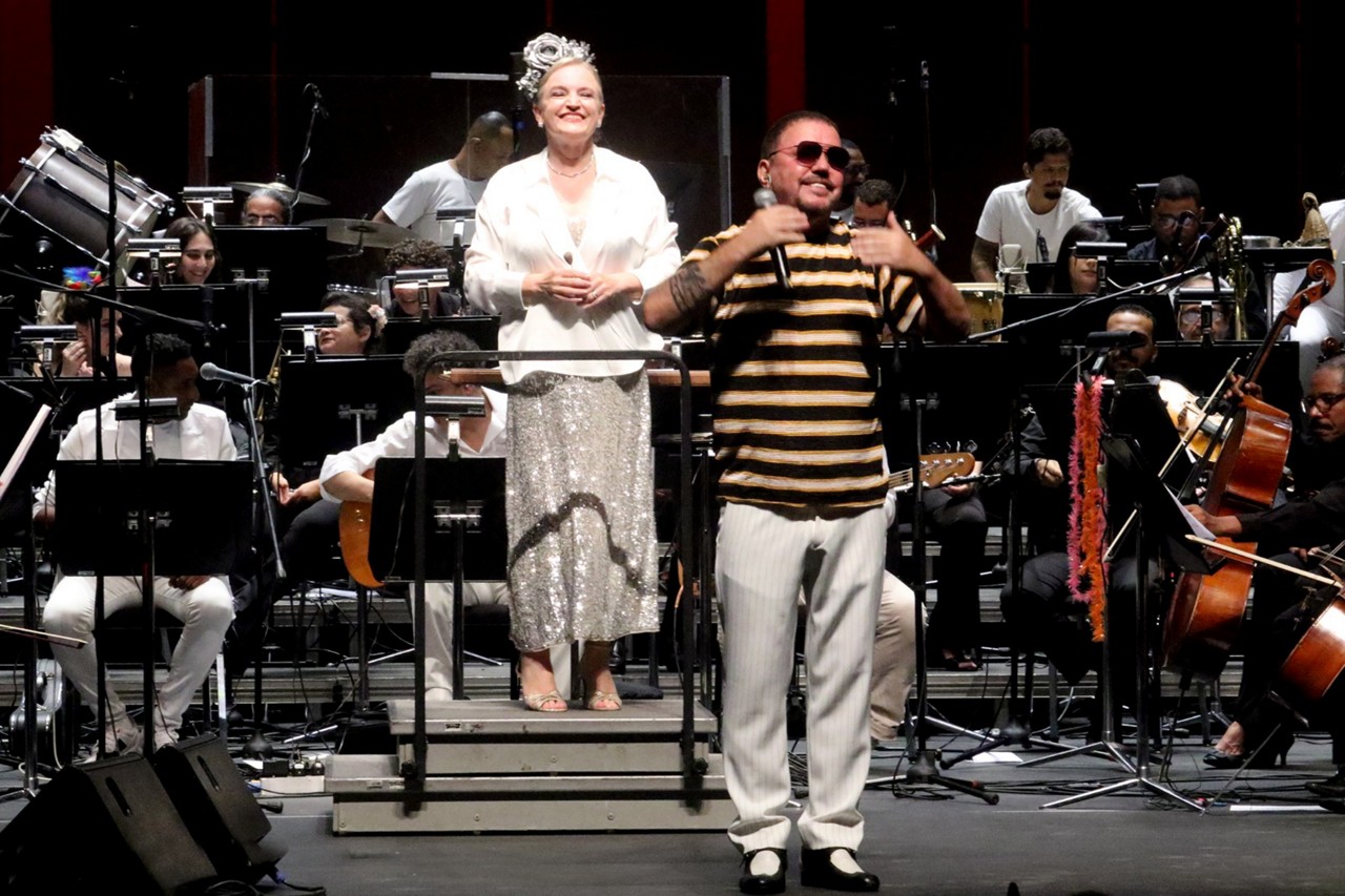 Tendo a Orquestra Sinfônica de Minas Gerais, ao fundo, a maestra Ligia Amadio e Toninho Geraes, hoje, no Palácio das Artes, apresentando e contagiando com o concerto "Sinfônica POP: Abertura do Carnaval da Liberdade - OSMG e CLMG convidam Toninho Geraes" 
