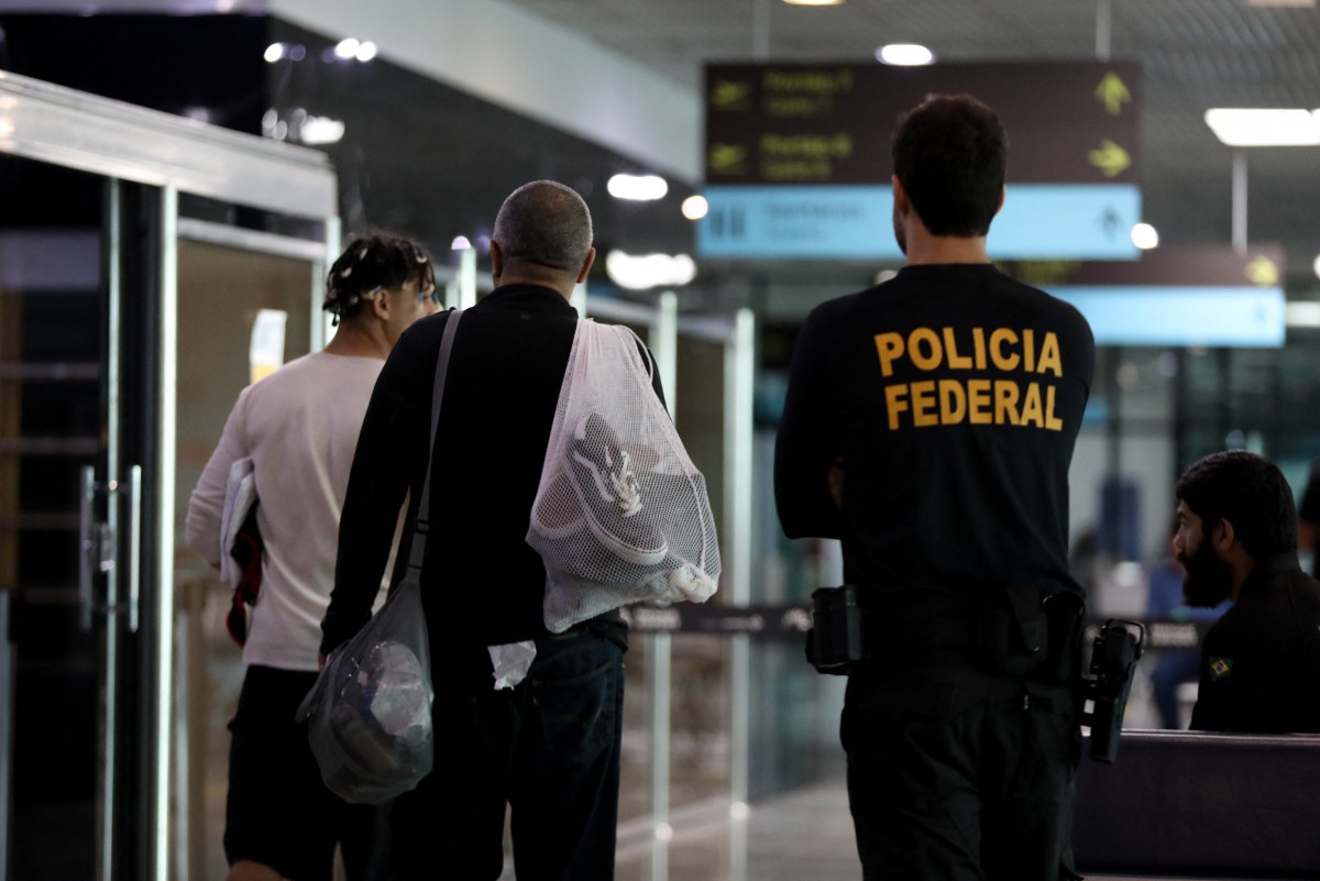 Brasileiros deportados dos Estados Unidos transitam pelo aeroporto de Manaus, onde tiveram correntes e algemas retirados por policiais federais após ordem de Lula