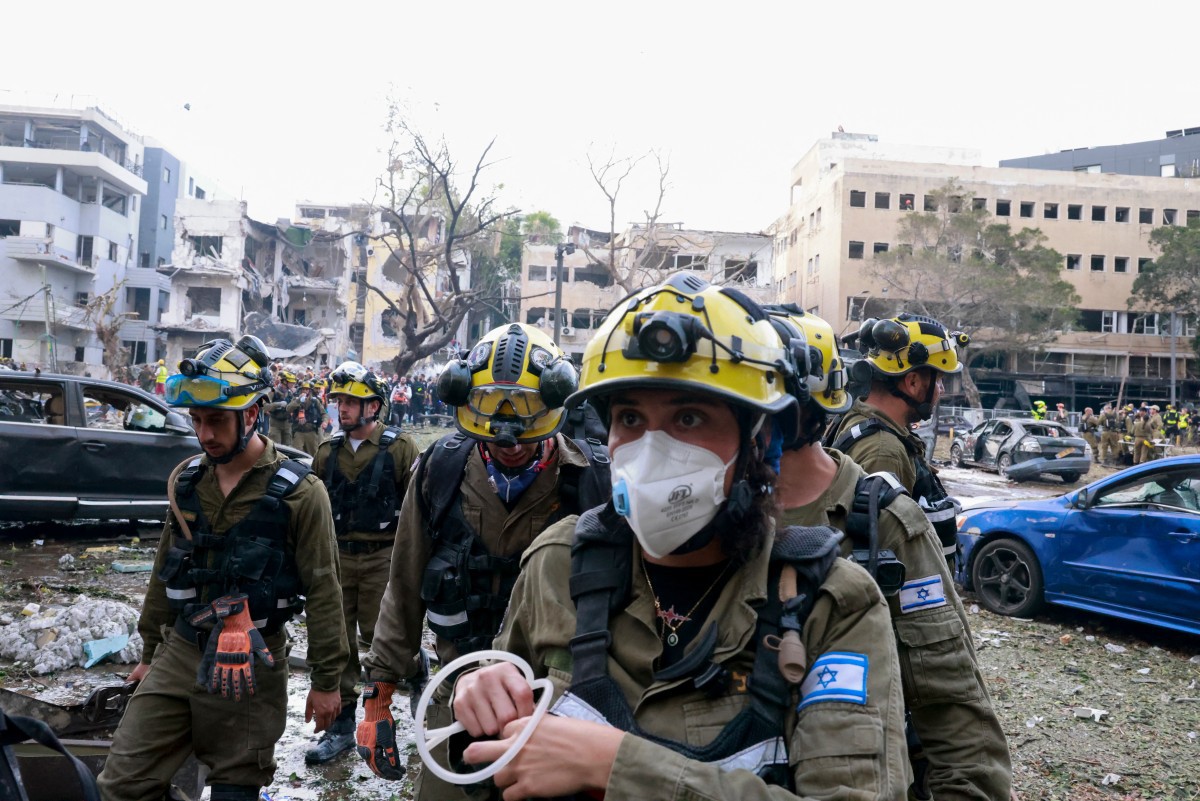 Equipes de resgate trabalham na cidade israelense de Tel Aviv após um ataque com mísseis iranianos em 16 de junho de 2025