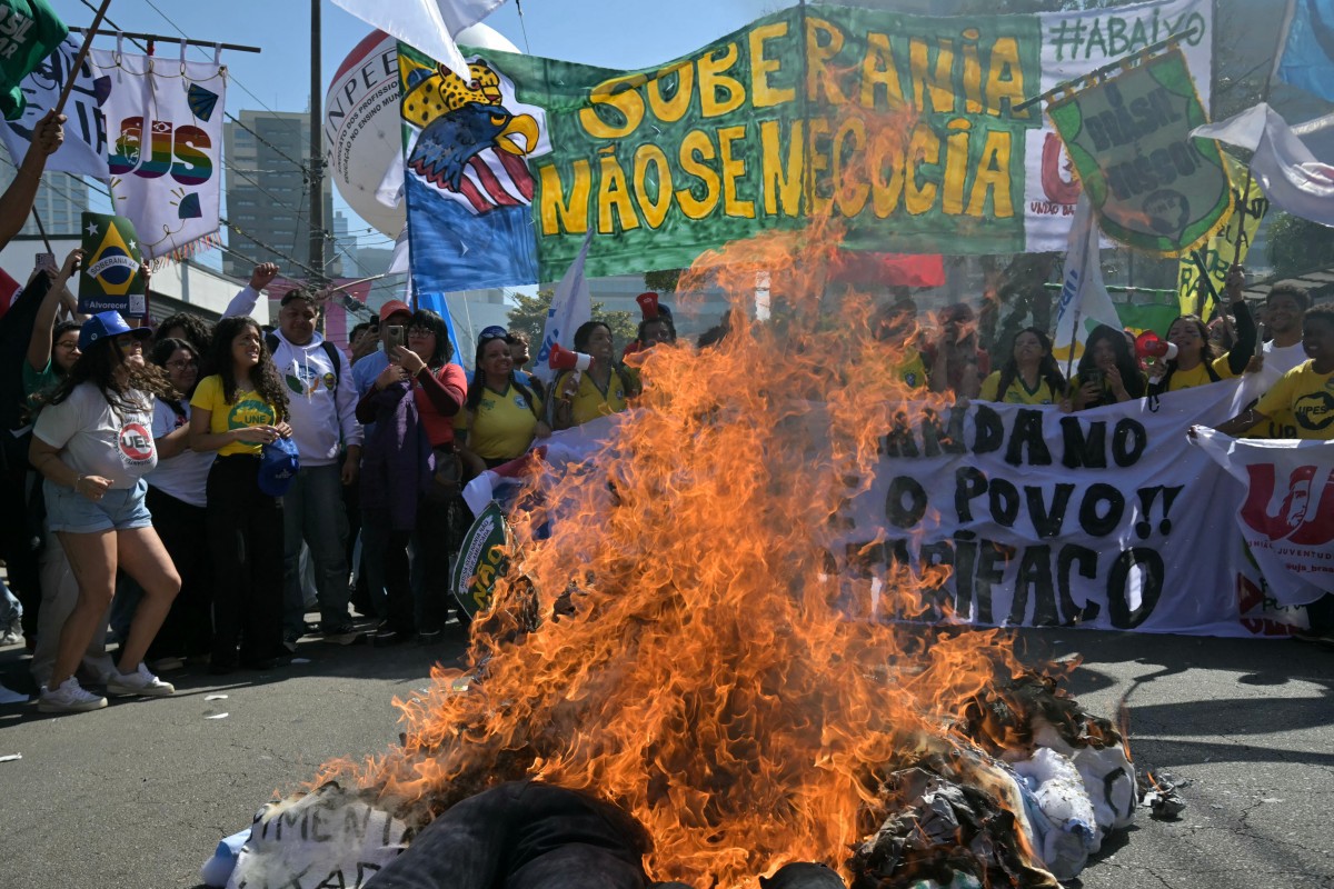Manifestantes queimam bonecos de Donald Trump e Jair Bolsonaro, em frente ao consulado norte-americano, na zona sul de São Paulo