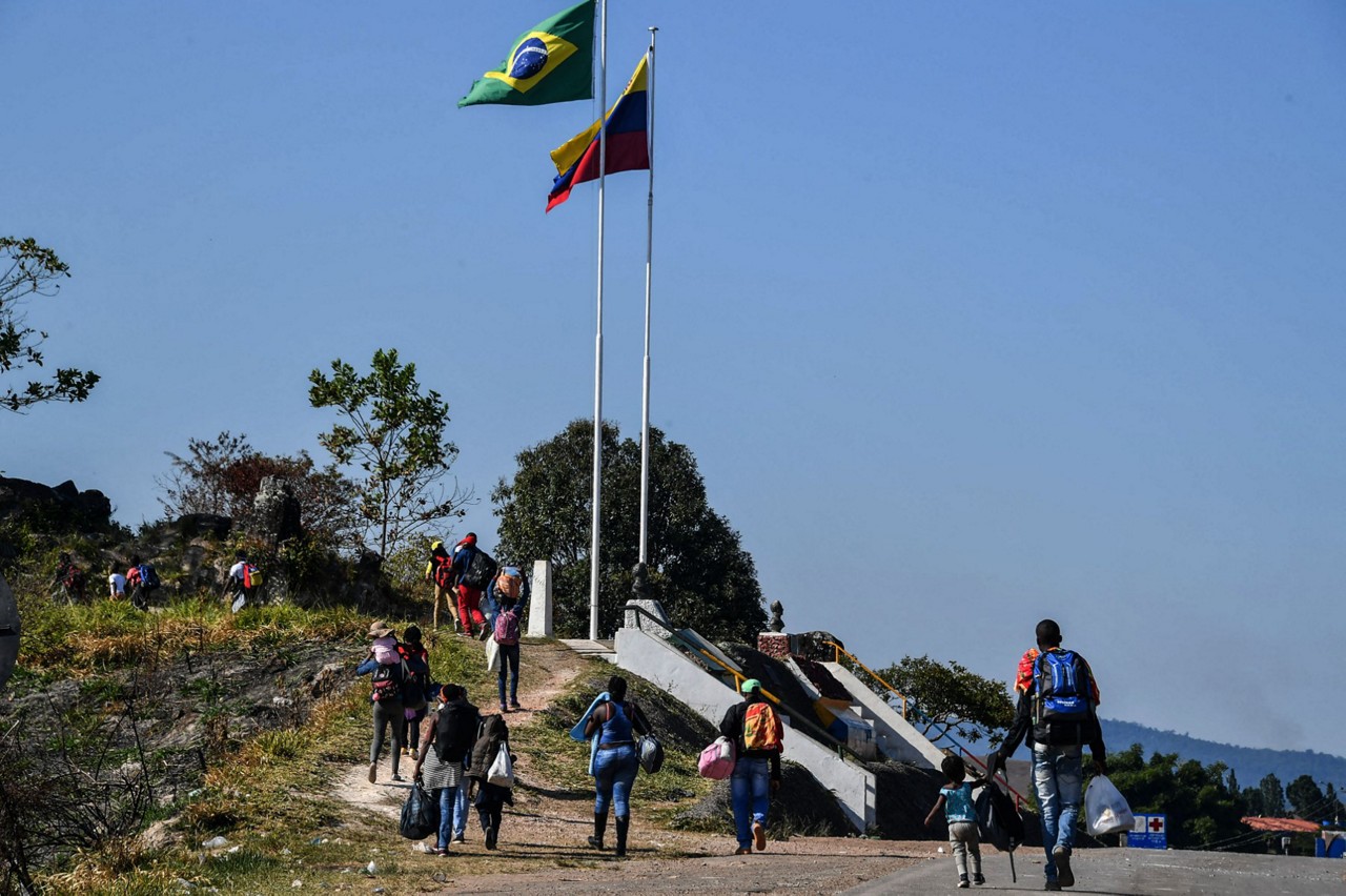 Refugiados venezuelanos cruzam a fronteira entre a Venezuela e o Brasil, na cidade de Pacaraima, em Roraima