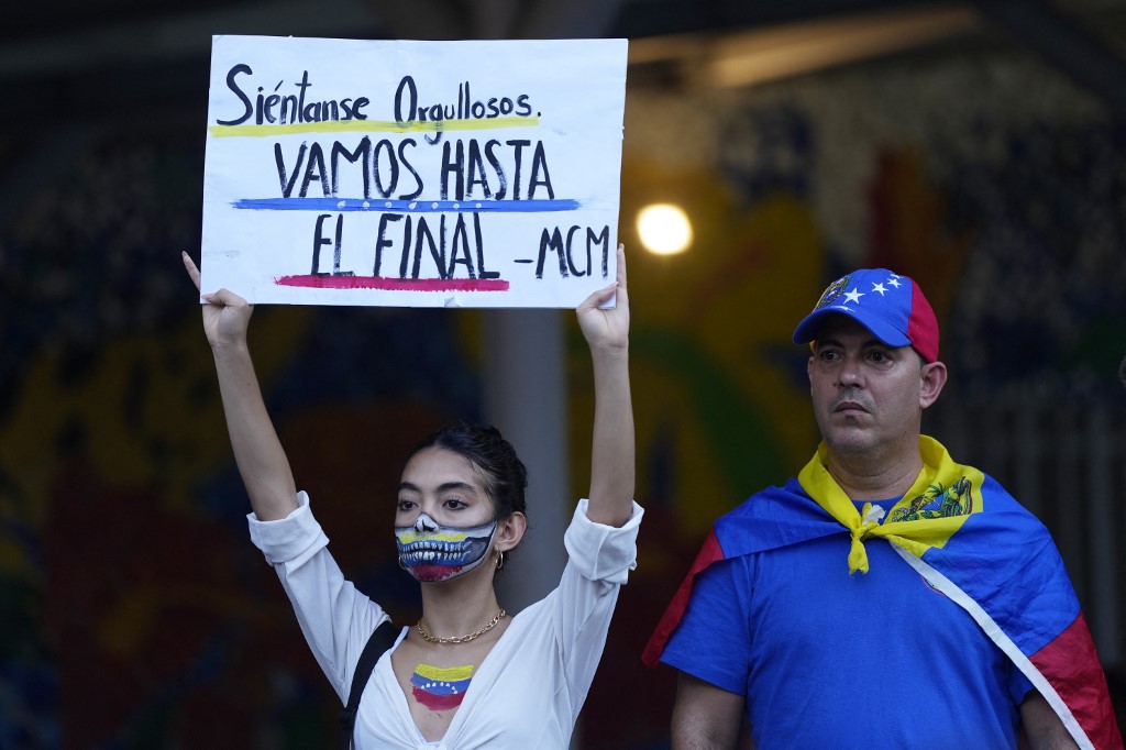 Venezuelana segura um cartaz que diz em espanhol "Sinta-se orgulhoso, estamos indo até o fim" durante protesto contra a suposta fraude eleitoral na controversa eleição presidencial da Venezuela