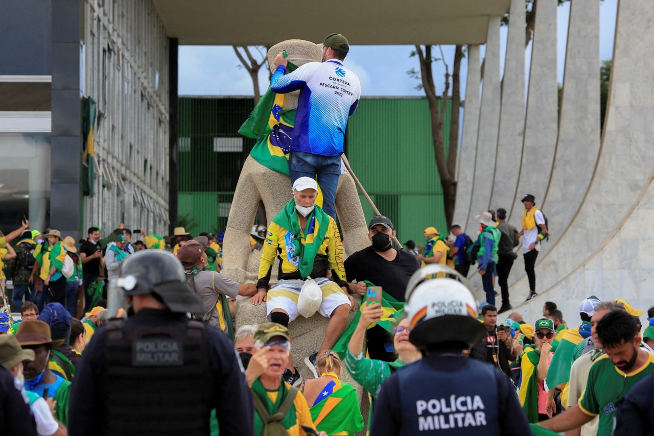 Policiais militares observam apoiadores do ex-presidente Jair Bolsonaro (PL) durante invasão e depredação da sede do Supremo Tribunal Federal (STF), em 8 de janeiro de 2023