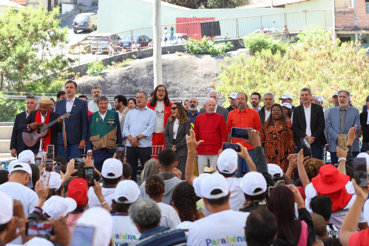 Autoridades cantam o hino nacional durante cerimônia com Lula no aglomerado da Serra 