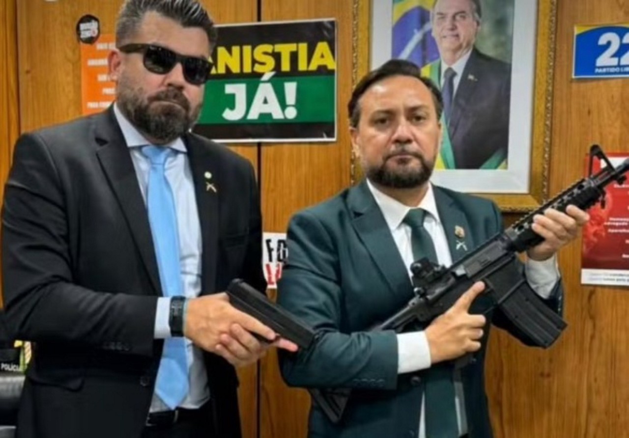 Delegado Caveira (esq.) exibe uma pistola em gabinete na Câmara; ao lado dele está o vereador Zezinho Lima, de Belém, que segura um fuzil