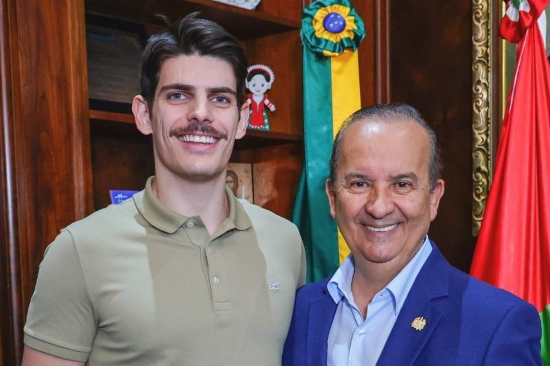 À esquerda, o servidor Samuel Moro Jacques, exonerado após vídeo em que o governador Jorginho Mello, à direita, aparece fazendo 'mão boba' em Michelle Bolsonaro
