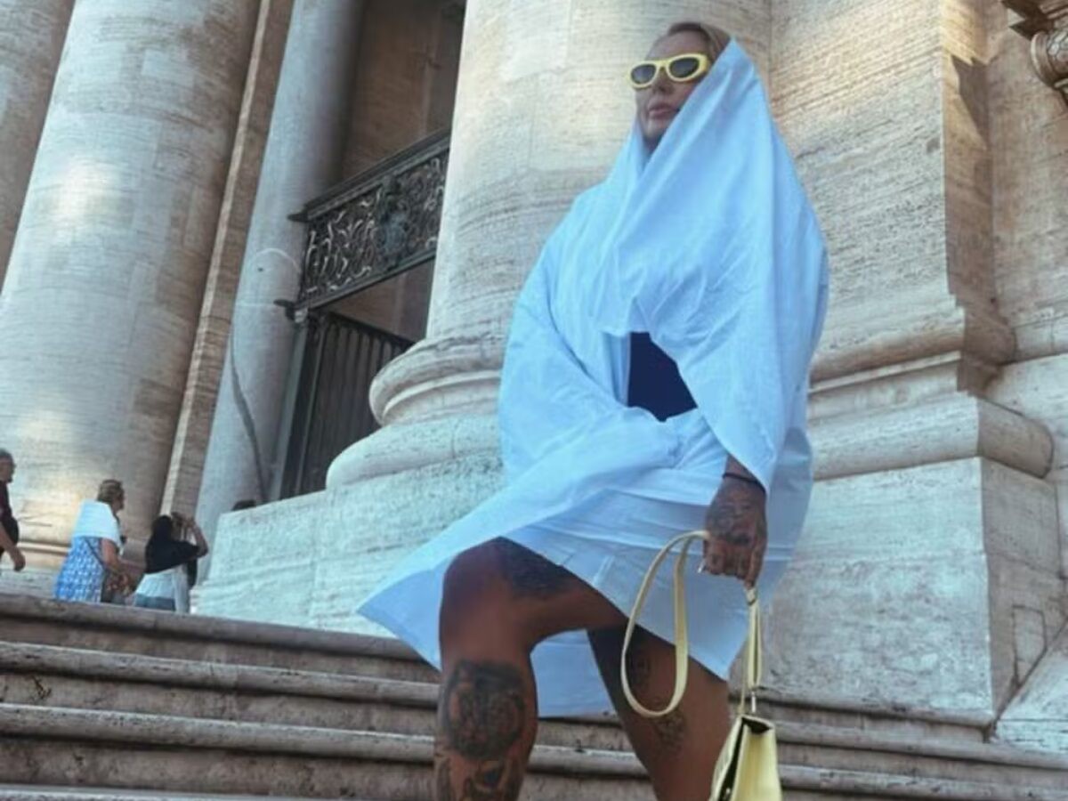 A influenciadora e tatuadora Sabrina Boing Boing, de 39 anos, contou nas redes sociais um episódio desconfortável vivido durante uma visita à Basílica de São Pedro, no Vaticano. Mesmo vestida com um macaquinho discreto, ela afirma ter sido abordada pelos seguranças e obrigada a cobrir o corpo com um pano fornecido no local. “Não era decote, não era pele demais. Era o formato do meu corpo”, escreveu. Sabrina disse ter seguido o código de vestimenta do Vaticano, que exige ombros e joelhos cobertos. No entanto, foi retirada da fila logo após o detector de metais, sem explicações. “Minha roupa era até mais comportada do que a de outras mulheres que estavam entrando com shortinho e regata”, desabafou. Apesar do desconforto, ela decidiu continuar a visita. “Me senti uma múmia, coberta da cabeça até a canela, no meio de um calor absurdo”, comentou, dizendo que a situação atraiu ainda mais olhares curiosos dos turistas. Conhecida pelo visual com tatuagens e dentes pontiagudos, Sabrina acredita que o constrangimento foi causado por preconceito. “Foi julgamento. Um preconceito disfarçado de regra”, afirmou.