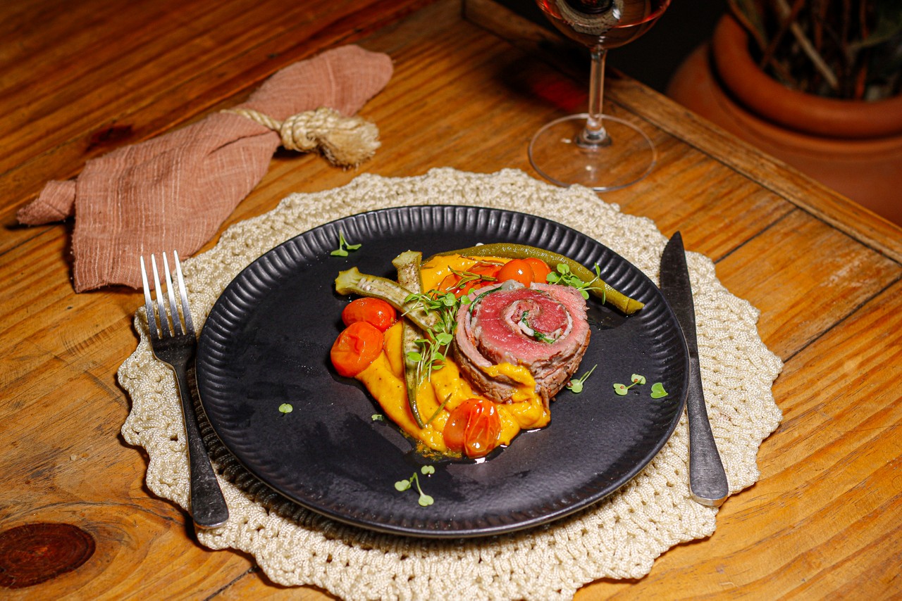 O Dengo de Vó, do restaurante Margô: rolê de filé, recheado de rúcula, charque, bacon e alho assado, acompanhado de um aveludado pure de cabotia ao leite de coco e dendê, tomates e quiabo e pimenta biquinho confitada no azeite
