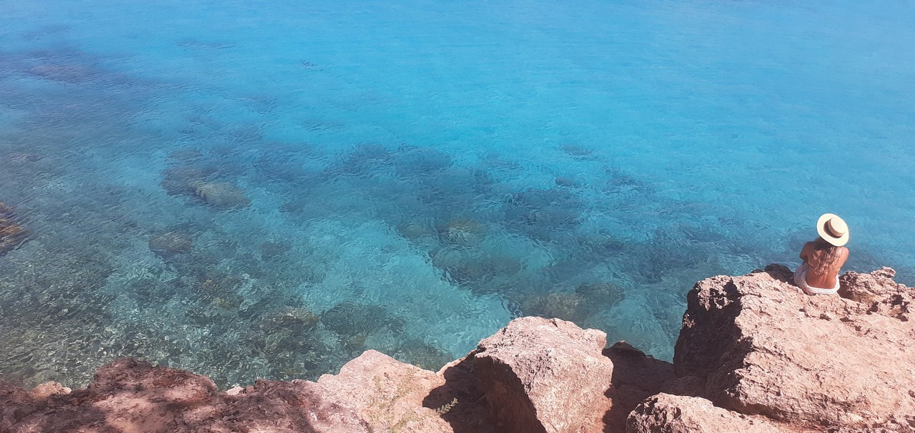 Turista contempla o belíssimo mar azul-turqueza de Curaçao