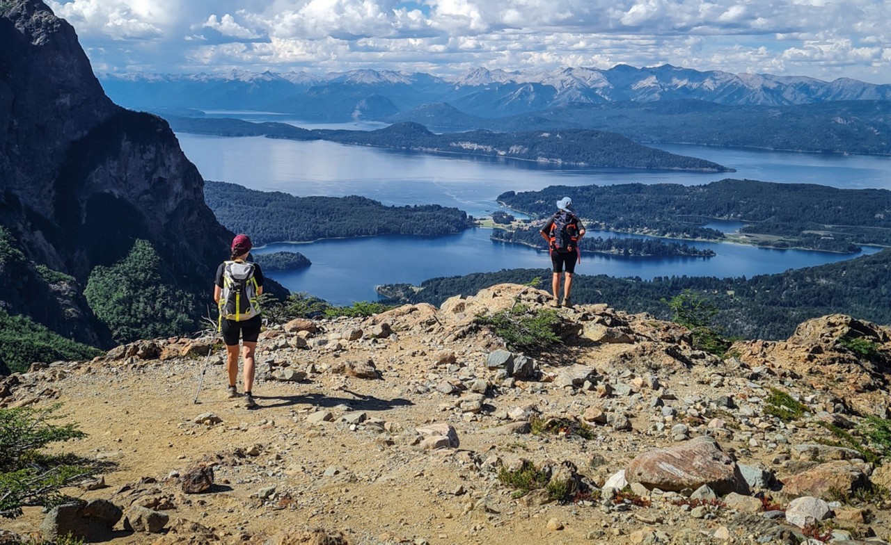 Turistas apreciam a paisagem em Bariloche do alto de uma montanha