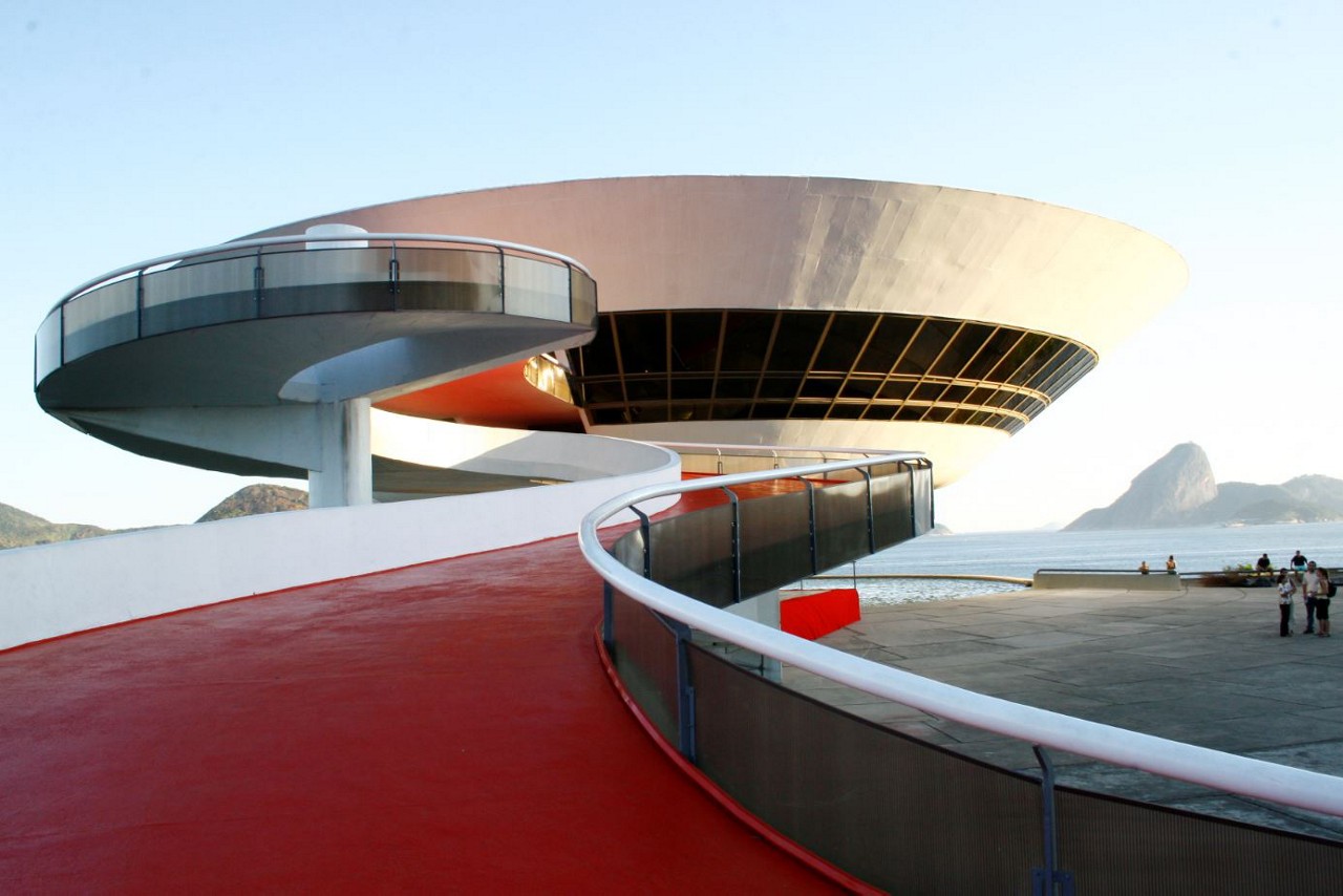 O Museu de Arte Contemporânea (MAC), uma obra de Oscar Niemeyer, tendo ao fundo a Baía de Guanabara e o Pão-de-Açúcar