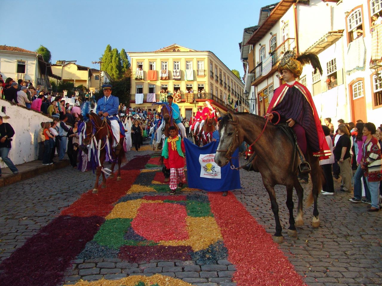 Ruas da cidade histórica são ornamentadas por tapetes de serragens coloridos