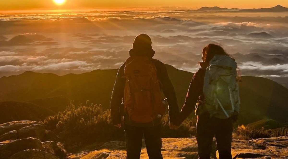 Casal observa o nascer do sol no pico da Bandeira, um dos locais mais frios de Minas